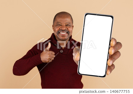 Mature African American man holding blank smartphone screen and giving thumbs up Mature African American man holding blank smartphone screen and giving thumbs up 140677755
