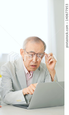 A senior man struggling with a problem while using his laptop. A senior man struggling with a problem while using his laptop. 140677953