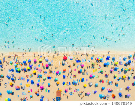 Aerial drone view of a crowded Mediterranean beach with people and colorful umbrellas. Aerial drone view of a crowded Mediterranean beach with people and colorful umbrellas. 140678149