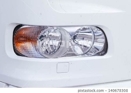 Close-up of the headlight of a modern minibus. Car front optics. Car headlight. Close-up of the headlight of a modern minibus. Car front optics. Car headlight. 140678308