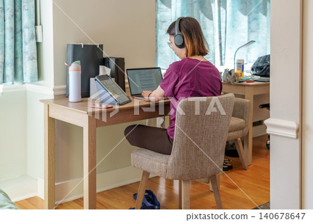 Concentrated learner utilizing technology in a comfortable home workspace 140678647