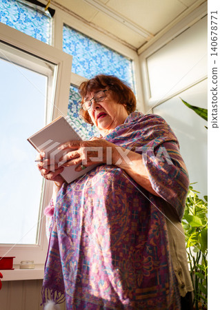 Caucasian elderly woman composing thoughtful notes near a window in a cozy interior. Learning and productive leisure. Senior education concept. Vertical Caucasian elderly woman composing thoughtful notes near a window in a cozy interior. Learning and productive leisure. Senior education concept. Vertical 140678771