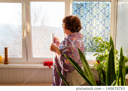 Elderly grandmother taking notes and developing new ideas in a bright room. Active retirement and intellectual engagement. Personal growth. Bottom view Elderly grandmother taking notes and developing new ideas in a bright room. Active retirement and intellectual engagement. Personal growth. Bottom view 140678783