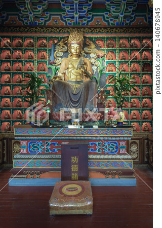 A golden statue of Guanyin Bodhisattva sits inside Chongqing millennium-old Luohan Temple. Behind the deity, hundreds of miniature alcoves form an intricate grid, This unique architecture defines the A golden statue of Guanyin Bodhisattva sits inside Chongqing millennium-old Luohan Temple. Behind the deity, hundreds of miniature alcoves form an intricate grid, This unique architecture defines the 140678945