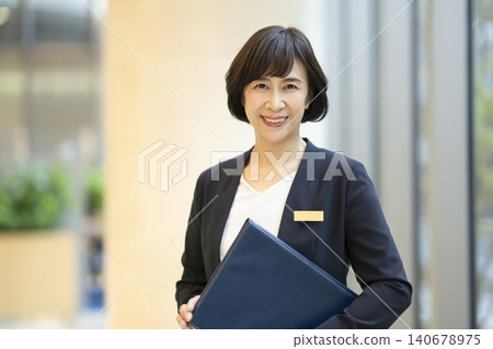 A portrait of a senior businesswoman smiling and looking directly at the camera. A portrait of a senior businesswoman smiling and looking directly at the camera. 140678975