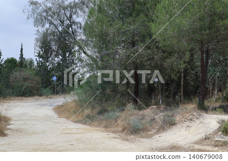 Prohibitory and information signs in a public park. Dirt path through a forest of trees. 140679008