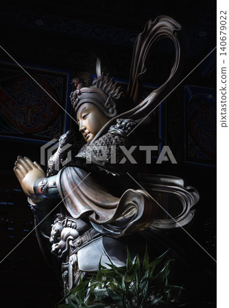 The statue of Skanda Bodhisattva or Wei Tuo, a revered Dharma protector who guards monasteries. Clad in intricate armor, the youthful general presses his hands together in a reverent anjali mudra 140679022