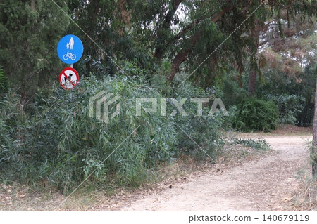 Prohibitory and information signs in a public park. It is prohibited to walk a dog. It is allowed to walk in the park on foot and ride a bicycle. Prohibitory and information signs in a public park. It is prohibited to walk a dog. It is allowed to walk in the park on foot and ride a bicycle. 140679119
