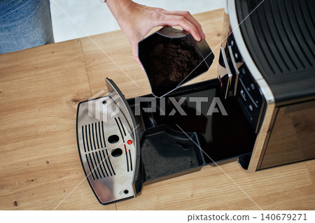 Person cleaning coffee machine grounds container Person cleaning coffee machine grounds container 140679271