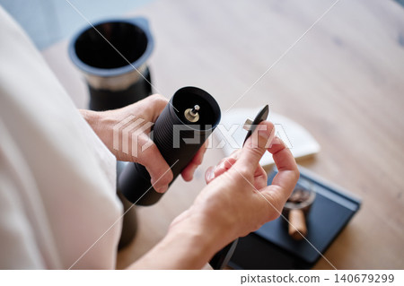 Hands adjusting manual coffee grinder before brewing Hands adjusting manual coffee grinder before brewing 140679299
