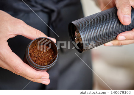 Fresh coffee grounds in hand grinder Fresh coffee grounds in hand grinder 140679303