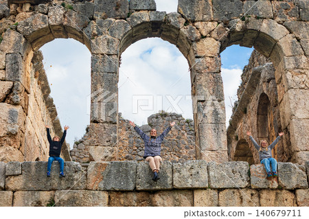Happy family in Roman bath of ancient Greek city Tlos in Lycia located on Lycian way. Famous historical site In Antalya region. Popular place for family travel on summer vacation. Fethiye, Turkey Happy family in Roman bath of ancient Greek city Tlos in Lycia located on Lycian way. Famous historical site In Antalya region. Popular place for family travel on summer vacation. Fethiye, Turkey 140679711