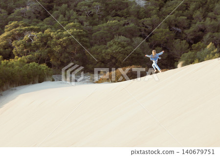 Happy child runs, jumps and having fun in sand dunes at Patara Beach, Turkey. Active travel lifestyle, sunny coastal landscape and freedom of movement during vacation in popular tourism destination Happy child runs, jumps and having fun in sand dunes at Patara Beach, Turkey. Active travel lifestyle, sunny coastal landscape and freedom of movement during vacation in popular tourism destination 140679751