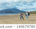 Boy and girl run and jump on Iztuzu Beach near Dalyan, Turkey. Joyful family travel moment with active lifestyle, sandy coast and carefree childhood by the sea. 140679780