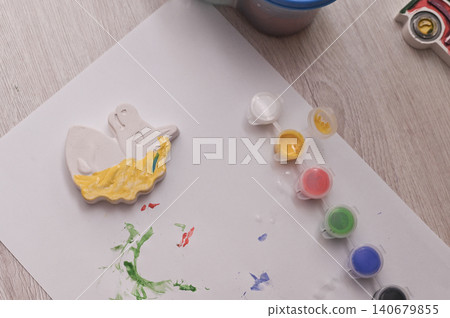 There are paints and plaster figure for coloring on table. horse figurine is partially painted by neat child. concept of needlework, children's activities, handicrafts. There are paints and plaster figure for coloring on table. horse figurine is partially painted by neat child. concept of needlework, children's activities, handicrafts. 140679855