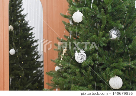 Christmas tree adorned with white ornaments, showcasing festive charm and elegance for holiday decor. Green Christmas tree with white baubles and ornaments, holiday atmosphere and festive cheer Christmas tree adorned with white ornaments, showcasing festive charm and elegance for holiday decor. Green Christmas tree with white baubles and ornaments, holiday atmosphere and festive cheer 140679856
