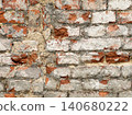 Close up of an old weathered brick wall with cracked plaster and exposed red bricks. Rustic grunge masonry texture background 140680222