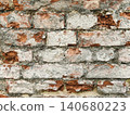 Close up of an old weathered brick wall with cracked plaster and exposed red bricks. Rustic grunge masonry texture background 140680223