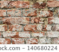 Close up of an old weathered brick wall with cracked plaster and exposed red bricks. Rustic grunge masonry texture background 140680224