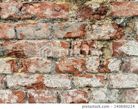 Close up of an old weathered brick wall with cracked plaster and exposed red bricks. Rustic grunge masonry texture background Close up of an old weathered brick wall with cracked plaster and exposed red bricks. Rustic grunge masonry texture background 140680224