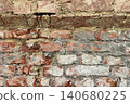Close up of an old weathered brick wall with cracked plaster and exposed red bricks. Rustic grunge masonry texture background 140680225