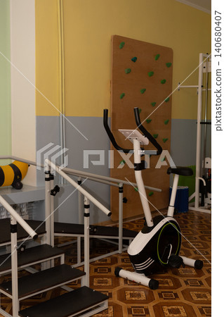 Indoor home gym fitness center with exercise bike and climbing wall in bright room. Indoor home gym fitness center with exercise bike and climbing wall in bright room. 140680407
