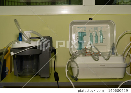 Professional medical suction machine with transparent canisters and tubing in clinical setting. 140680429