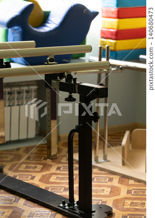 Black metal physical therapy equipment with adjustable bars and blue inflatable dolphin in clinic setting. Black metal physical therapy equipment with adjustable bars and blue inflatable dolphin in clinic setting. 140680473