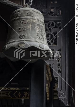 The weathered bronze bell hangs with a quiet, ancient dignity inside the Luohan Temple, its surface etched with traditional characters that speak of centuries past. With a unique, undulating scalloped The weathered bronze bell hangs with a quiet, ancient dignity inside the Luohan Temple, its surface etched with traditional characters that speak of centuries past. With a unique, undulating scalloped 140680531