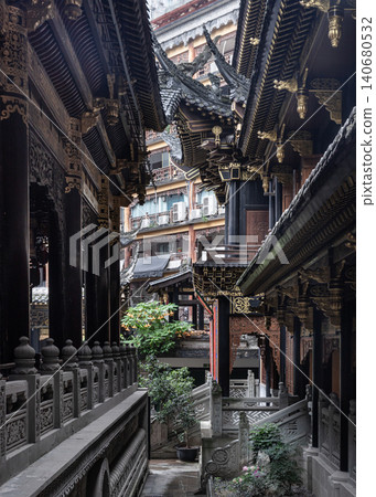 Inside Luohan Temple, traditional wooden pavilions flank a narrow stone courtyard. Tiered, swept roofs with dark ceramic tiles slice into the skyline. Elaborate golden ornaments accent the dark wooden Inside Luohan Temple, traditional wooden pavilions flank a narrow stone courtyard. Tiered, swept roofs with dark ceramic tiles slice into the skyline. Elaborate golden ornaments accent the dark wooden 140680532