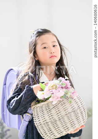 A Japanese girl with a school backpack on her back and a basket of flowers. A Japanese girl with a school backpack on her back and a basket of flowers. 140680616