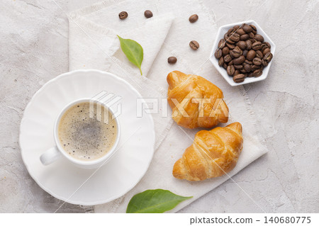 Coffee glass, roasted coffee beans and bread on the white table Coffee glass, roasted coffee beans and bread on the white table 140680775