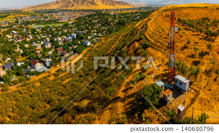 Aerial View of Telecommunications Tower Overlooking Town and Mountains 140680796
