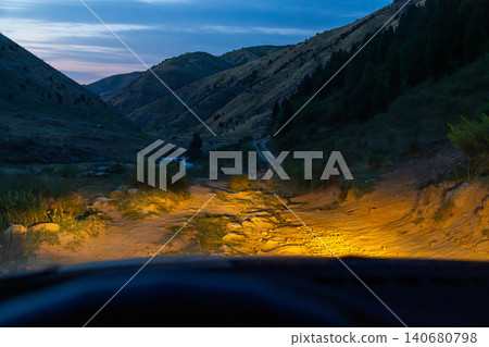 Driving on a Dirt Road in a Valley at Dusk Driving on a Dirt Road in a Valley at Dusk 140680798