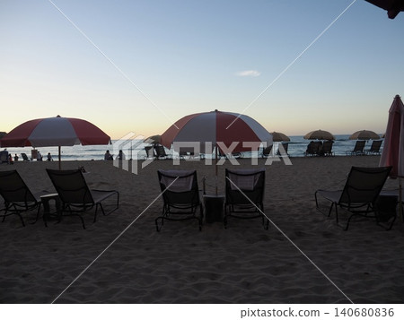 A beach at sunset with parasols A beach at sunset with parasols 140680836