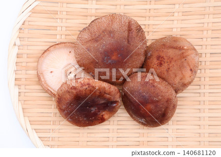 An overhead photo of fresh shiitake mushrooms arranged on a bamboo sieve. An overhead photo of fresh shiitake mushrooms arranged on a bamboo sieve. 140681120