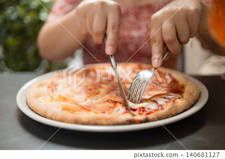Happy young woman eating delicious Italian pizza at outdoor cafe in Europe Happy young woman eating delicious Italian pizza at outdoor cafe in Europe 140681127