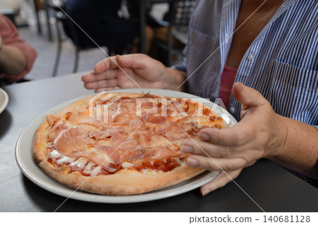 Happy young woman eating delicious Italian pizza at outdoor cafe in Europe Happy young woman eating delicious Italian pizza at outdoor cafe in Europe 140681128