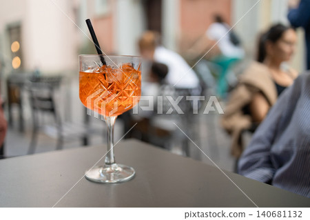 Close-up of refreshing Aperol Spritz cocktail on a table of outdoor European cafe Close-up of refreshing Aperol Spritz cocktail on a table of outdoor European cafe 140681132