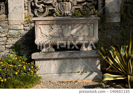 Antique carved stone basin on a stone wall backdrop Antique carved stone basin on a stone wall backdrop 140681185
