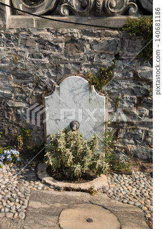 Old stone drinking fountain on a rustic stone wall Old stone drinking fountain on a rustic stone wall 140681186