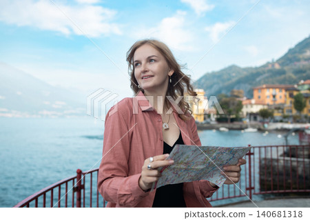 Young woman tourist holding a paper map at Lake Como Young woman tourist holding a paper map at Lake Como 140681318