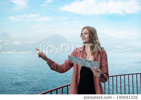 Young woman tourist holding a paper map at Lake Como Young woman tourist holding a paper map at Lake Como 140681326