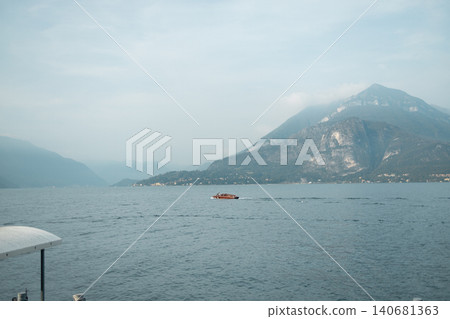 Picturesque summer landscape of a calm blue alpine lake with green mountains under a bright sky in a famous European travel destination. Picturesque summer landscape of a calm blue alpine lake with green mountains under a bright sky in a famous European travel destination. 140681363