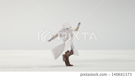 Woman posing outdoors in winter snow landscape with reaching arm Woman posing outdoors in winter snow landscape with reaching arm 140681373
