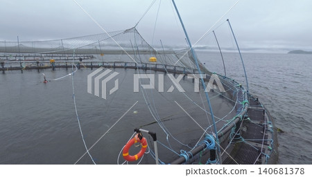 Large fish farm in the water with nets under cloudy sky as background Large fish farm in the water with nets under cloudy sky as background 140681378