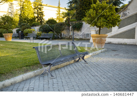 Empty wooden bench in historic courtyard garden Empty wooden bench in historic courtyard garden 140681447
