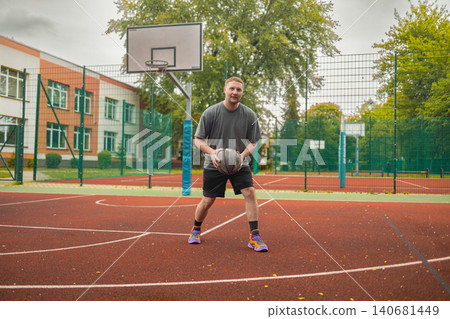 Full shot man holding basketball ball on outdoor court Full shot man holding basketball ball on outdoor court 140681449