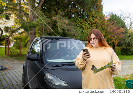 Woman talking on phone calling roadside assistance near car Woman talking on phone calling roadside assistance near car 140681516