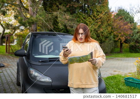 Woman talking on phone calling roadside assistance near car Woman talking on phone calling roadside assistance near car 140681517